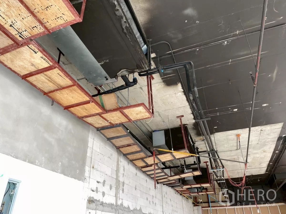 พื้นที่ขายปลีก ให้เช่า - ภาพใกล้ของท่อดักท์ ถาดสาย และระบบท่อดับเพลิงที่เพดาน