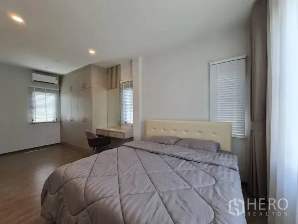 Detached House for rent in Samut Prakan - Spacious master bedroom with built-in wardrobe, vanity and wood floors.