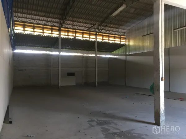 Warehouse for rent in Min Buri, Bangkok - Spacious warehouse interior with high metal roof, ventilation panels, concrete floor and support columns.