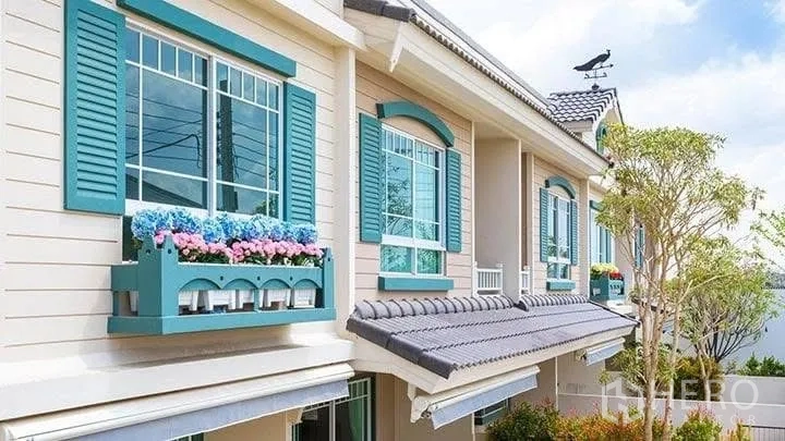 Townhouse for rent in Bang Phli, Samut Prakan - Pastel townhouse facade with teal shutters and flower boxes beneath large windows.