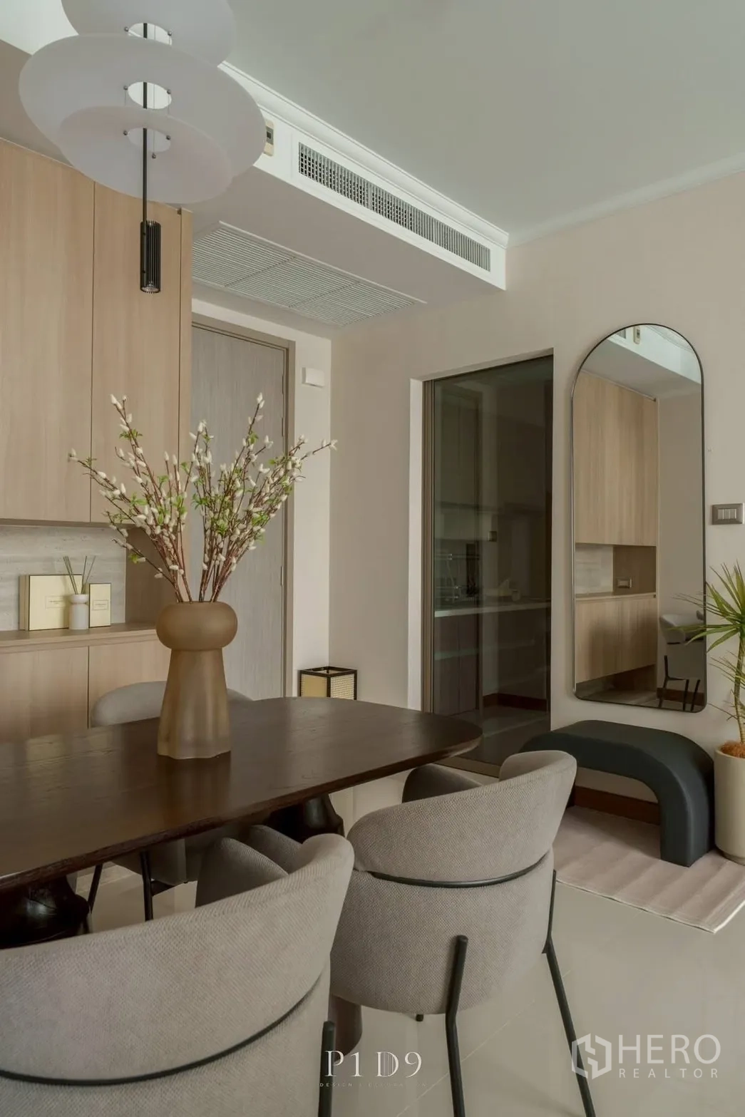 Condominium for rent in Watthana, Bangkok - Dining space with a tall mirror and sliding glass door to the kitchen.