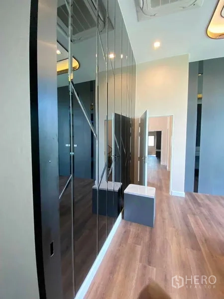 Detached House for sale in Don Mueang, Bangkok - Corridor with mirrored wardrobes and wood flooring under recessed lighting.