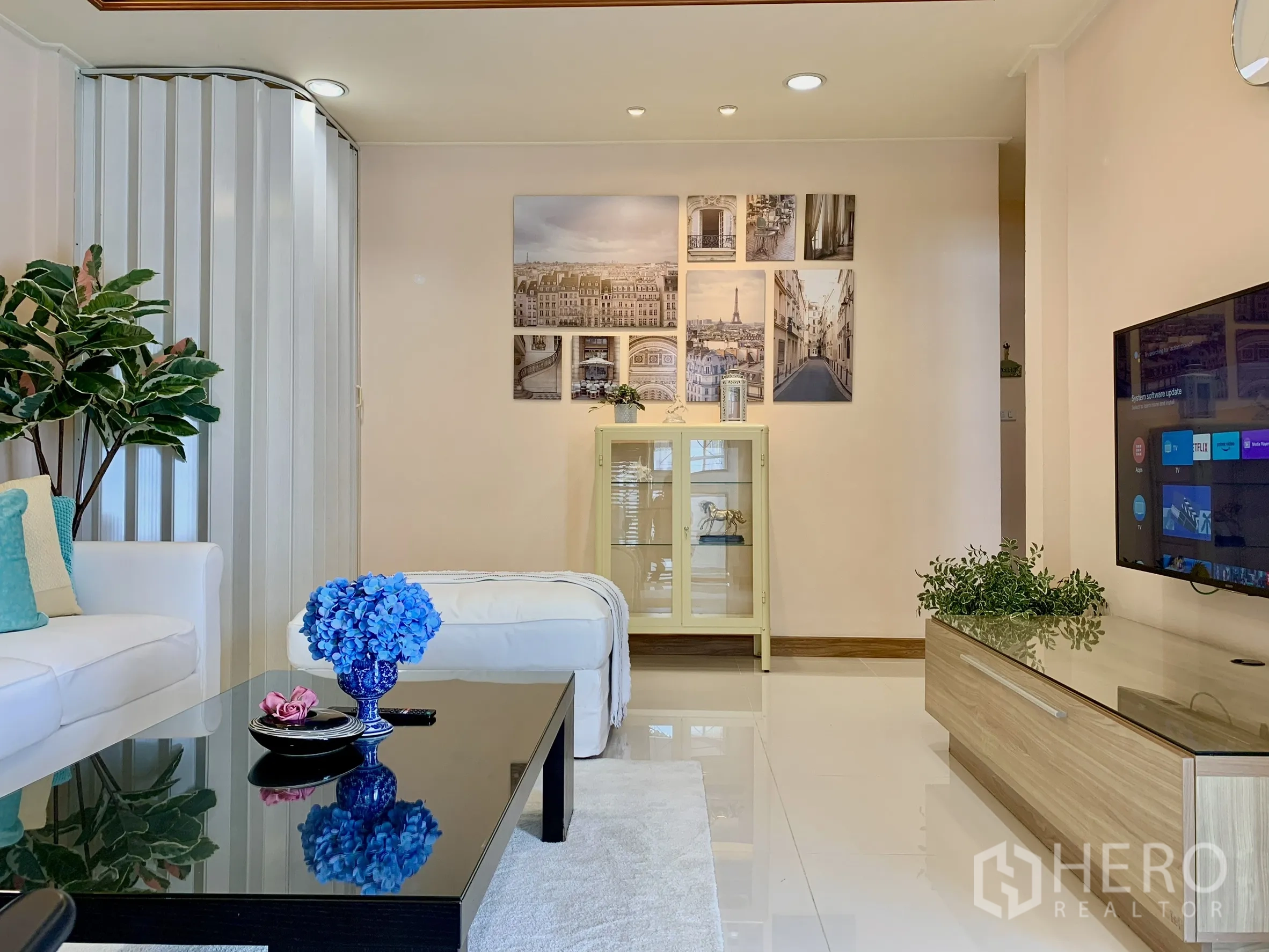 บ้านเดี่ยว for rent in Saphan Sung, Bangkok - พื้นที่นั่งเล่นพร้อมโซฟาสีขาว หมอนอิง ต้นไม้ในบ้าน และไฟฝ้าซ่อนแสง.