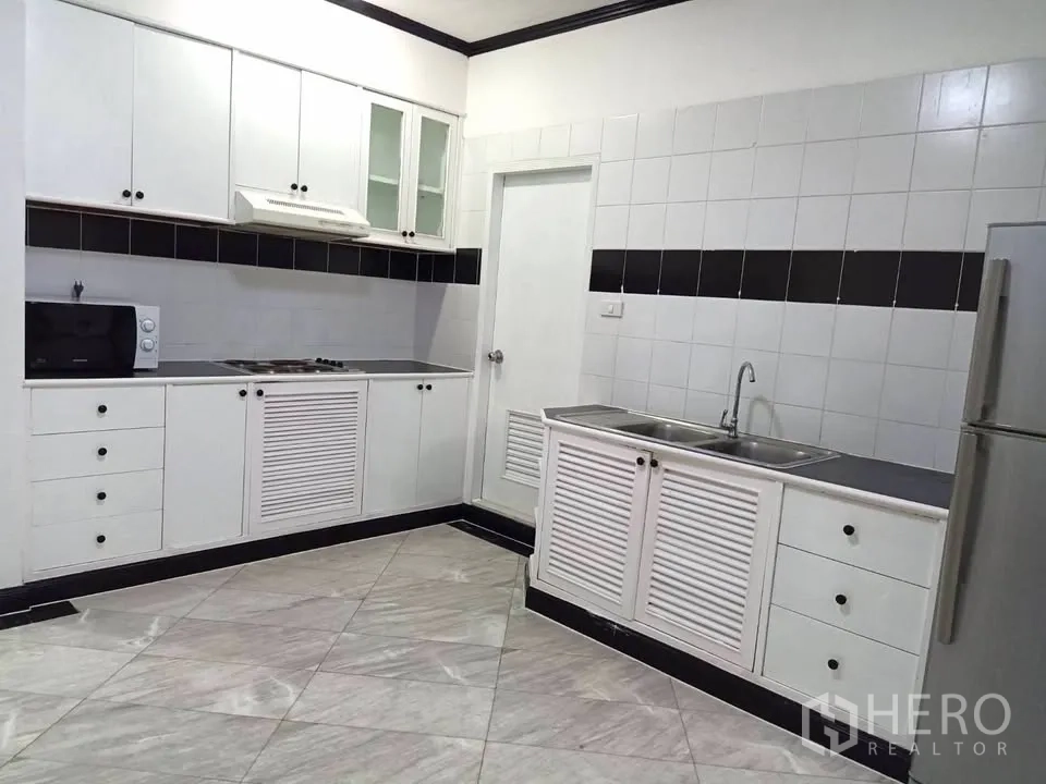 คอนโด for rent in Watthana, Bangkok - ครัวครบด้วยตู้บน-ล่างสีขาว เตาไมโครเวฟ อ่างล้างจาน และตู้เย็น
