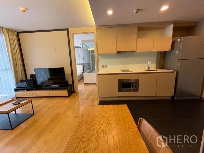 คอนโด ขายในWatthana, Bangkok - ครัวโทนไม้สว่าง มีเตา ไมโครเวฟ และทางเข้าห้องนอน