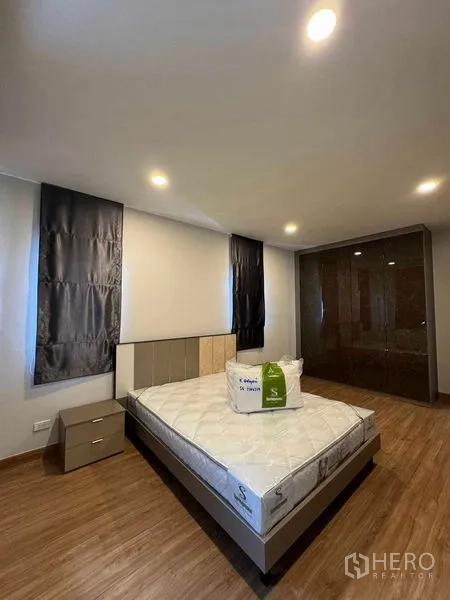 Detached House for rent in Don Mueang, Bangkok - Cozy bedroom with new mattress, side table and built-in wardrobe.