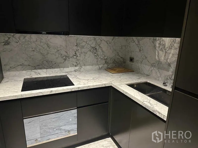 公寓 出租在Watthana, Bangkok - L形厨房，大理石台面，电磁炉与不锈钢水槽。