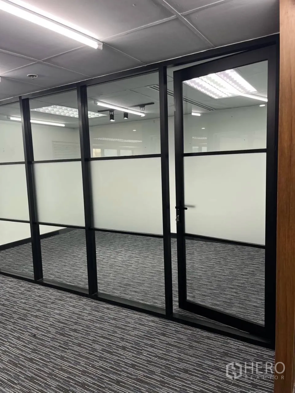 Office Space for rent in Khlong Toei, Bangkok - Close-up of a glass partition with a framed door and frosted lower panels.