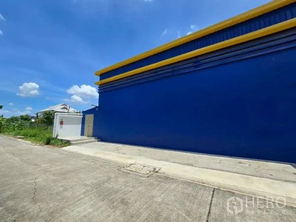 คลังสินค้า ให้เช่าหรือขายในKhlong Toei, Bangkok - ผนังด้านข้างสีน้ำเงินยาวติดถนนคอนกรีตเงียบสงบ