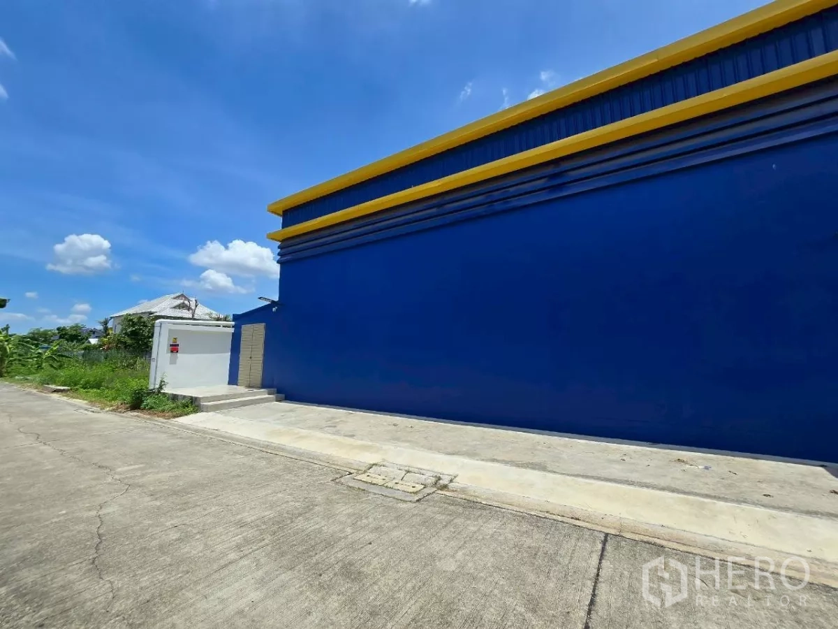 คลังสินค้า ให้เช่าหรือขายในKhlong Toei, Bangkok - ผนังด้านข้างสีน้ำเงินยาวติดถนนคอนกรีตเงียบสงบ