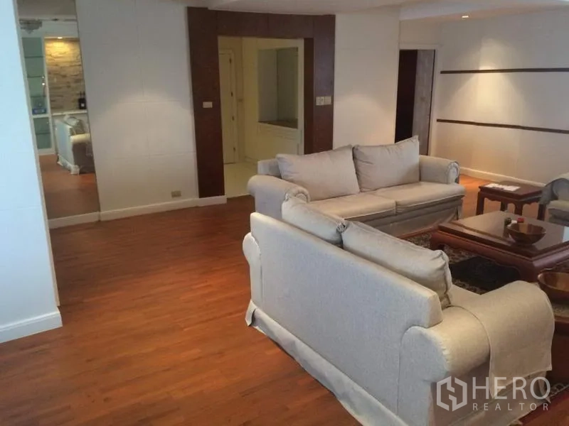 คอนโด ให้เช่าในKhlong Toei, Bangkok - พื้นที่รับแขกแบบเปิด พร้อมโซฟาคู่ พื้นไม้ และผนังบิลท์อิน ที่คอนโด President Park คลองเตย