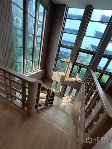 พื้นที่ขายปลีก ให้เช่าในPhaya Thai, Bangkok - บันไดไม้รับแสงข้างผนังกระจกสูงจรดเพดาน