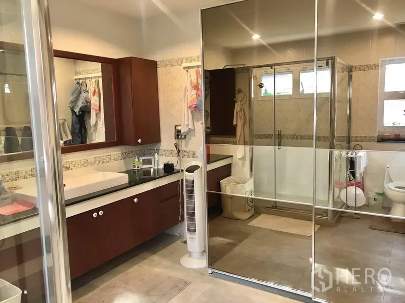 独立式住宅 出租 - 宽敞浴室，长台盆、超大镜面、玻璃淋浴间与座厕，暖色瓷砖装饰。