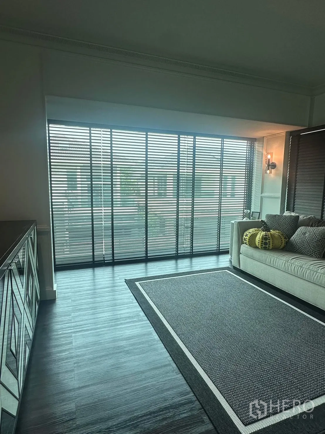 บ้าน ให้เช่าในLat Krabang, Bangkok - โซนพักผ่อนพร้อมโซฟา ตู้กระจก และหน้าต่างแบบบานเกล็ดเต็มผนัง