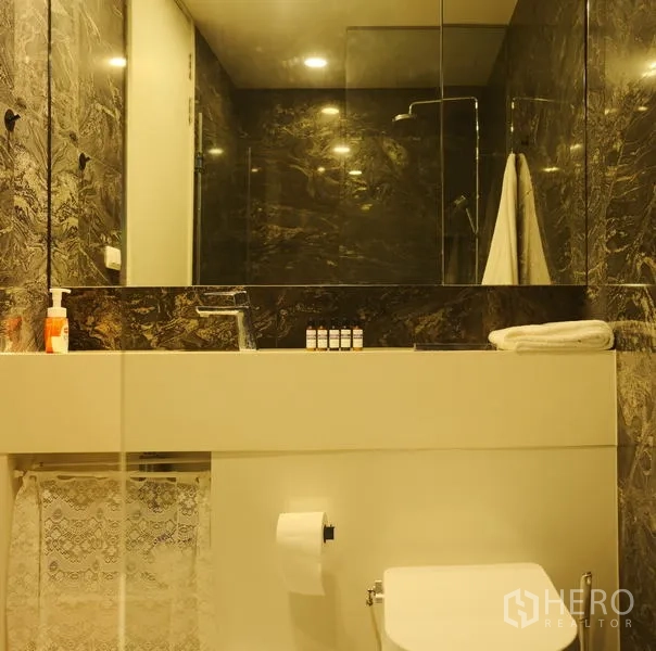 公寓 出租在Bang Rak, Bangkok - 卫浴配大镜面、台盆、马桶与深色石纹墙面