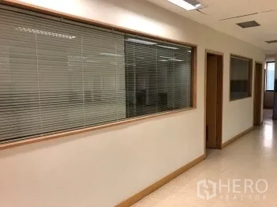 办公空间 出租或出售在Bang Rak, Bangkok - 巴吞旺区大楼内光线充足的办公室走廊，带百叶玻璃窗。