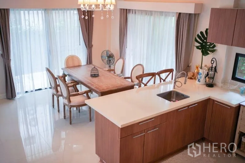 บ้าน ให้เช่าในSai Mai, Bangkok - มุมทานอาหารและไอส์แลนด์ครัว ในห้องโปร่งสว่างพร้อมผ้าม่านโปร่งและโคมระย้า