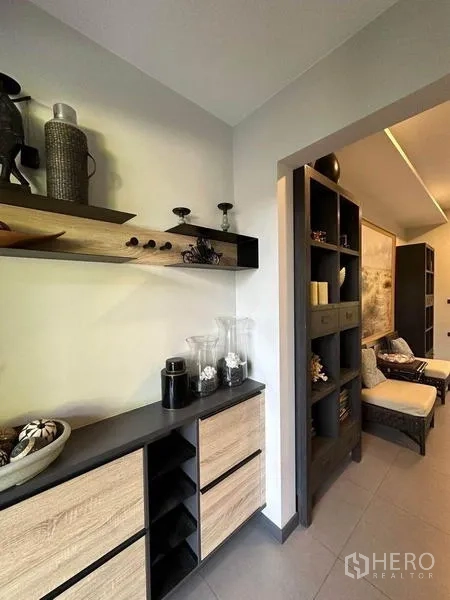 Townhouse for rent or sale in Bang Phli, Samut Prakan - Hallway with built-in wood cabinets and floating shelves styled with decorative pieces.