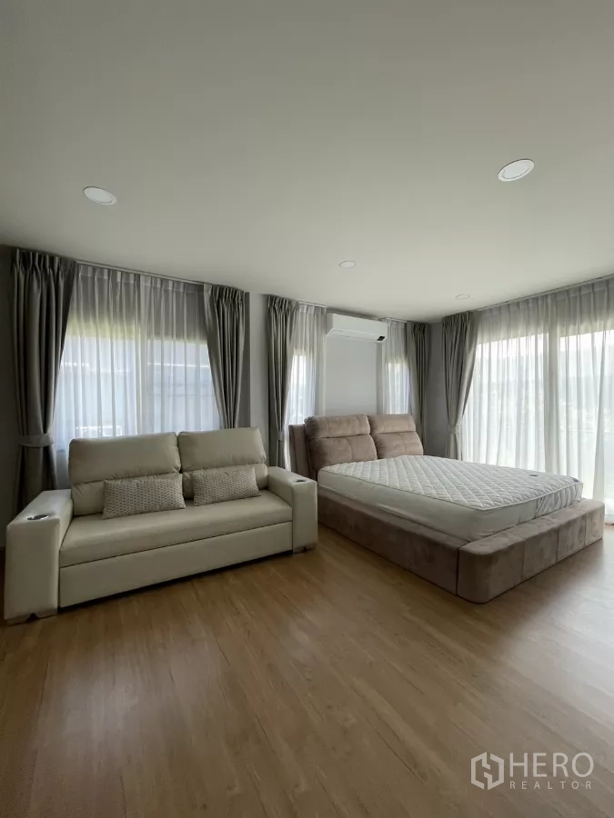 Detached House for rent in Bang Phli, Samut Prakan - Spacious master bedroom with large windows, upholstered bed and cream sofa.