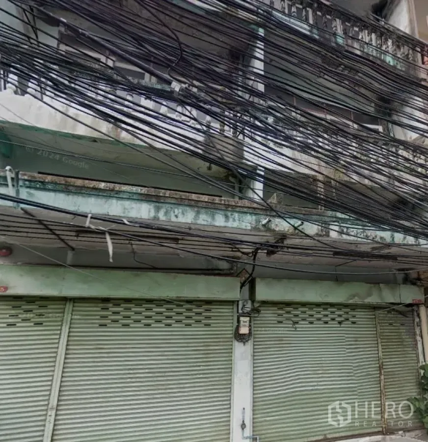 อาคารพาณิชย์ ให้เช่าในPhra Khanong, Bangkok - ด้านหน้าอาคารพาณิชย์สภาพเดิม บานประตูเหล็กม้วน ระเบียง และสายไฟพาดเต็ม