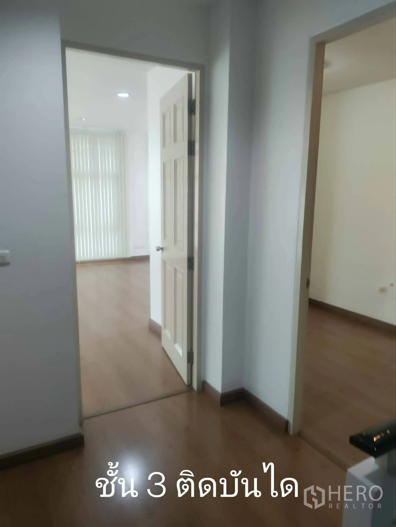 Home Office for rent in Lat Phrao, Bangkok - Hallway on upper floor with doors to adjoining rooms and wood flooring.