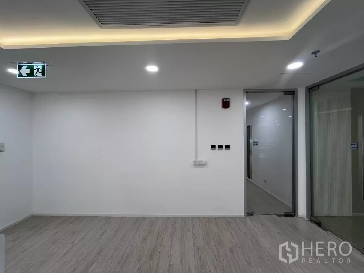 办公空间 for rent in Din Daeng, Bangkok - 简洁接待区，吊顶灯、紧急出口标志与玻璃门。
