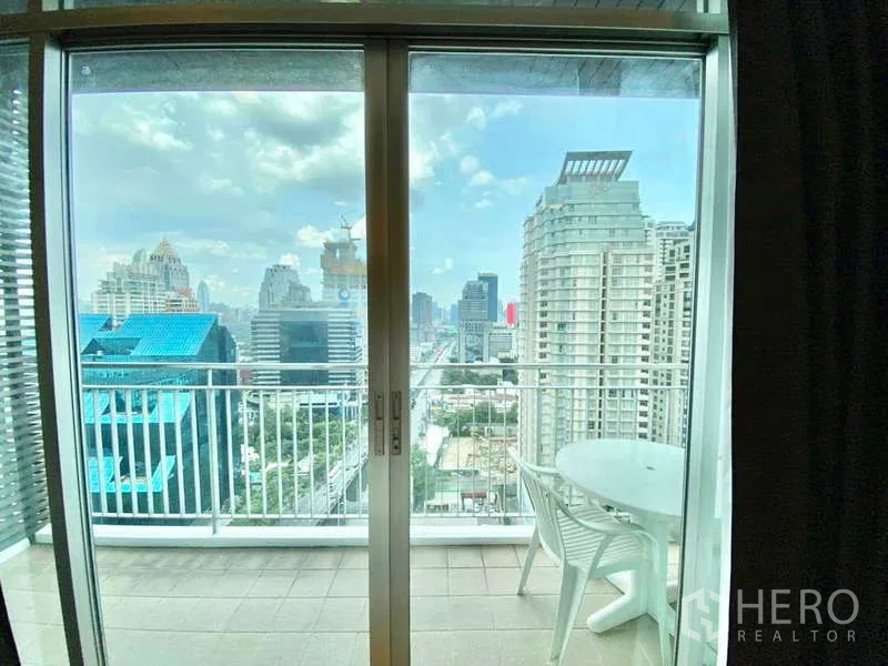 公寓 出租或出售在Sathon, Bangkok - 阳台小桌椅，俯瞰沙吞商圈天际线。