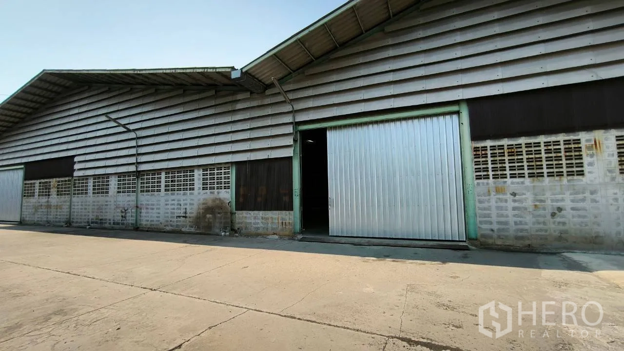 Factory for rent in Mueang Samut Prakan, Samut Prakan - Factory exterior with sliding metal doors and a loading apron.