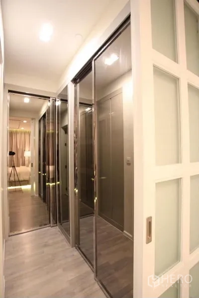 Condominium for rent or sale in Watthana, Bangkok - Hallway with sliding mirrored wardrobes and recessed lighting.