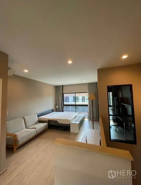 Townhouse for rent in Yan Nawa, Bangkok - Master suite with sitting area, recessed lights, and expansive glazing.