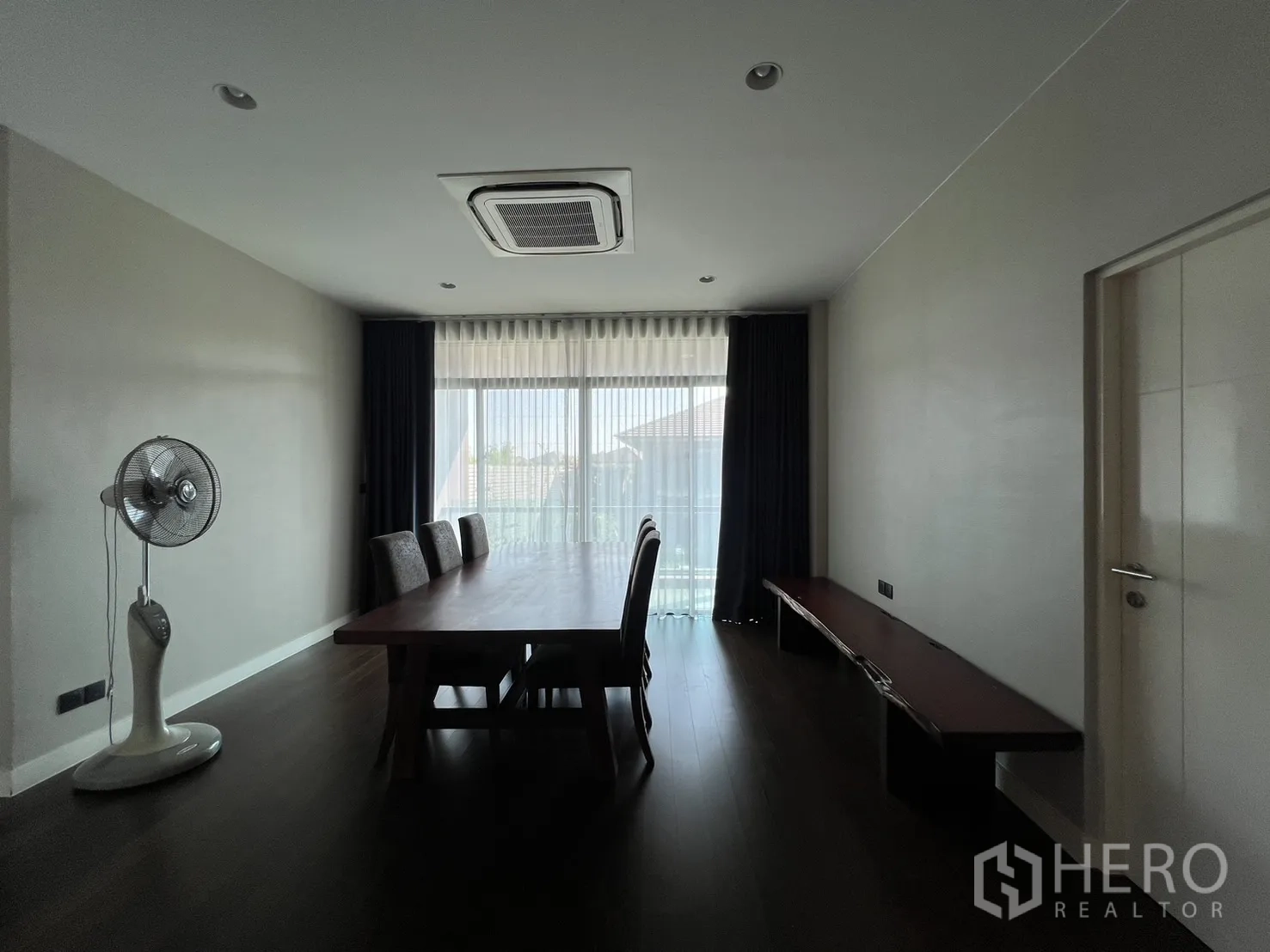 Detached House for rent or sale in Bang Kapi, Bangkok - Upstairs family or dining room with long table and balcony doors.