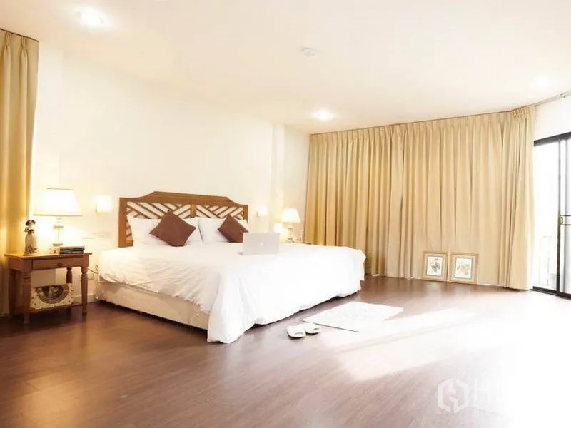 บ้าน ให้เช่าในKhlong Toei, Bangkok - ห้องนอนมาสเตอร์กว้าง พื้นไม้ และแสงไฟนุ่มนวล