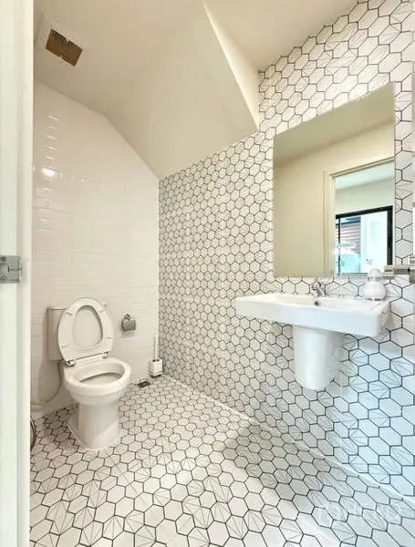 联排别墅 出租在Bang Phli, Samut Prakan - 浴室铺白色六角砖，坐便与壁挂式洗手盆。