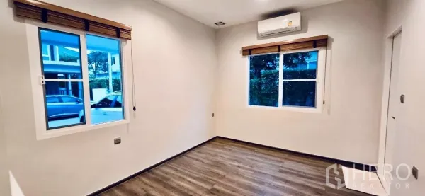 Detached House for rent in Samut Prakan - Bright ground-floor bedroom with two windows and air conditioning.