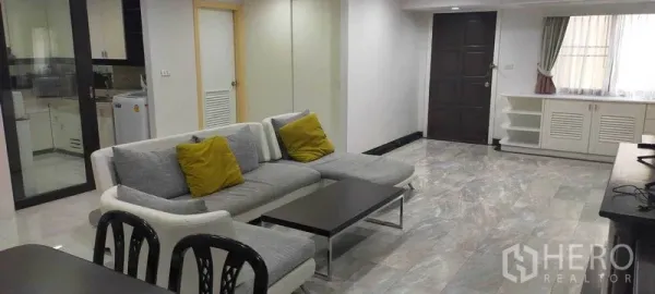 คอนโด ให้เช่าในWatthana, Bangkok - ห้องนั่งเล่นกว้าง พื้นลายหินอ่อน โซฟามุมสีเทา และตู้บิลท์อิน