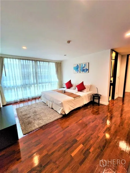 公寓 出租在Bang Rak, Bangkok - 宽大的卧室，铺地毯与床头柜，配大窗。