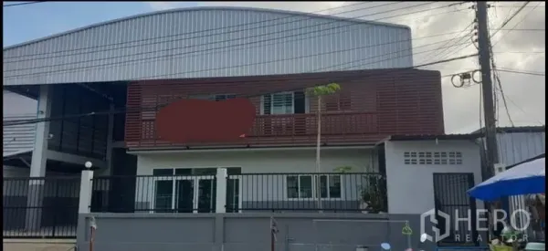 货栈 出租在Khlong Luang, Pathum Thani - 带围栏的现代仓库外观，配两层办公室和金属外墙。