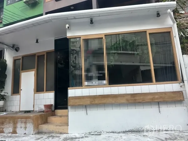 带办公室的家 出租在Watthana, Bangkok - 临街整面落地窗与遮檐射灯的门面展示区。
