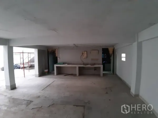 Warehouse for rent in Chatuchak, Bangkok - Ground‑floor workshop area beneath the mezzanine with built‑in counters and support pillars.