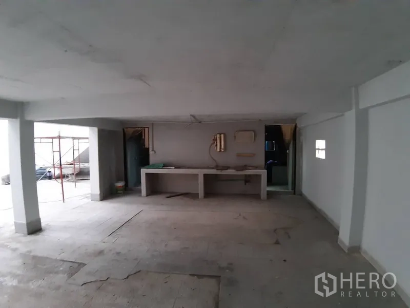 Warehouse for rent in Chatuchak, Bangkok - Ground‑floor workshop area beneath the mezzanine with built‑in counters and support pillars.
