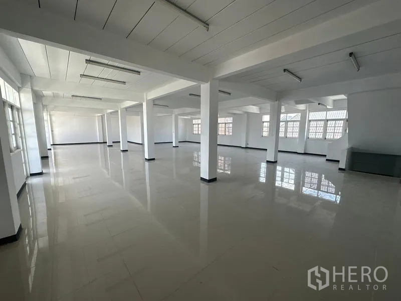 Home Office for rent in Phra Khanong, Bangkok - Wide office hall with tiled floors, column grid and overhead strip lights.