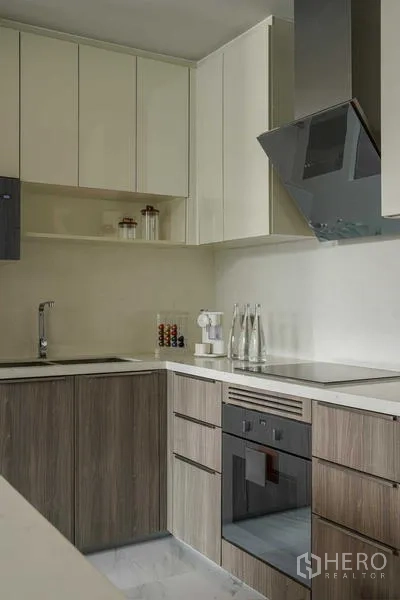 Condominium for rent - Close‑up of kitchen cabinetry with electric cooktop, oven and range hood.