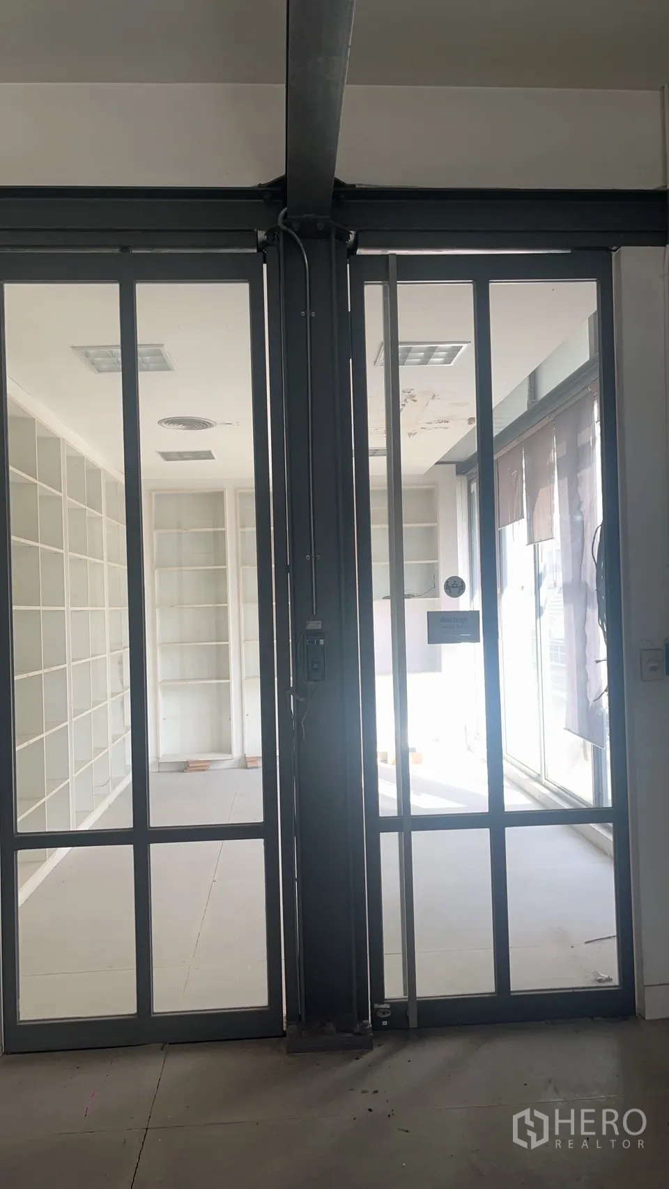 零售空间 出租在Watthana, Bangkok - 双扇玻璃门通向明亮房间，设有内置搁架和自然采光