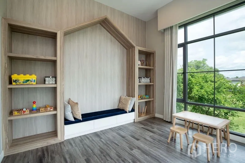 独立式住宅 出租在Bang Phli, Samut Prakan - 家庭活动室，木质嵌入式书架与坐榻，整面落地窗观景。
