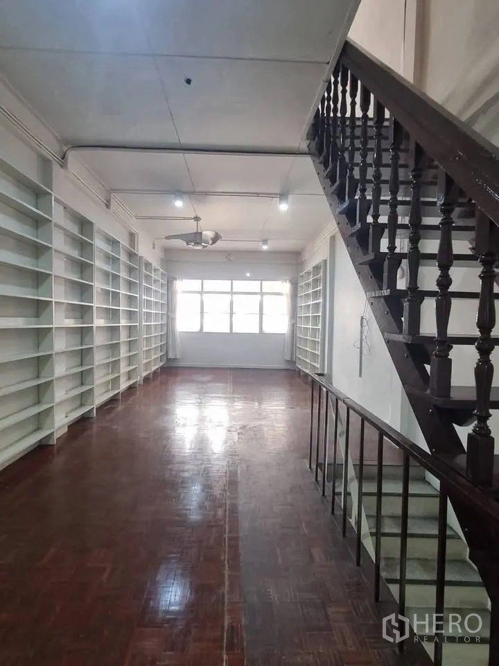 ตึกแถว for rent in Phra Khanong, Bangkok - ห้องยาวมีชั้นวางบิวท์อินสีขาวสองฝั่ง พื้นปาร์เกต์ และบันได.
