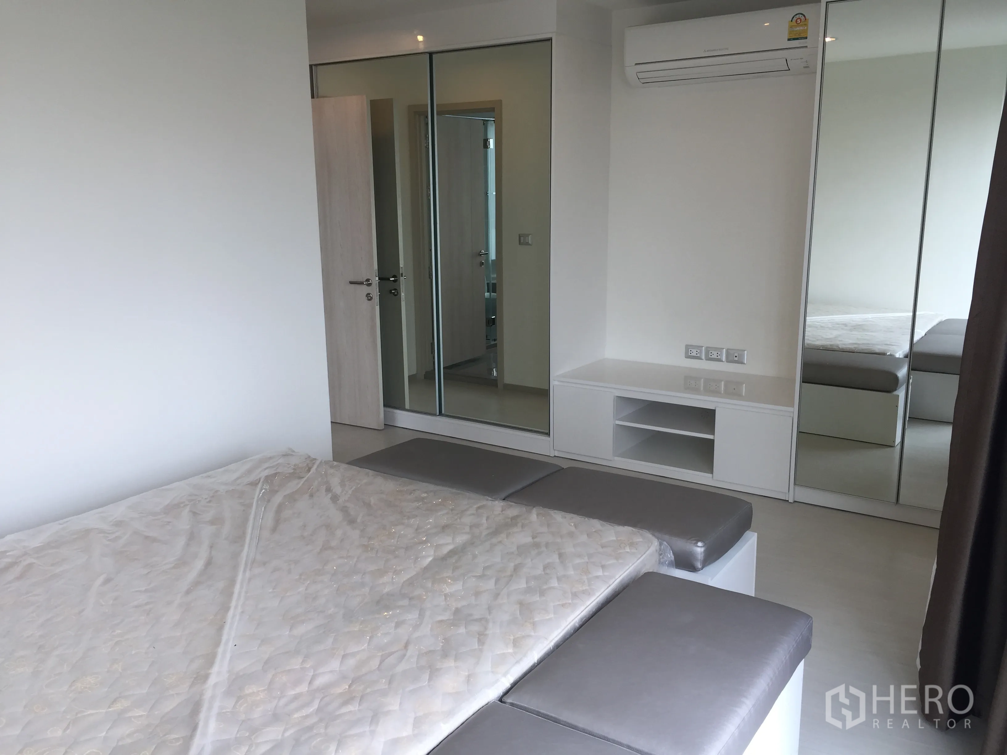 คอนโด ให้เช่าในKhlong Toei, Bangkok - ห้องนอนหลักพร้อมตู้เสื้อผ้าบานกระจก เตียงขนาดใหญ่ และเครื่องปรับอากาศ