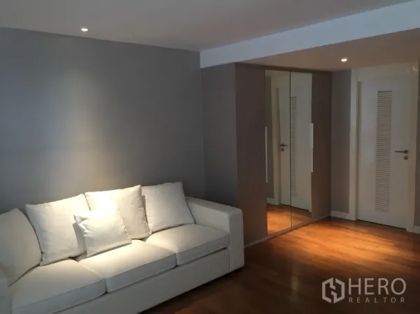 คอนโด ให้เช่าในWatthana, Bangkok - มุมนั่งเล่นสว่างด้วยโซฟาสีขาว ตู้เสื้อผ้าบานกระจก และพื้นไม้โทนอุ่น