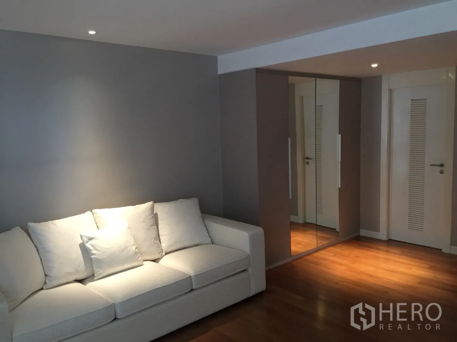 คอนโด ให้เช่าในWatthana, Bangkok - มุมนั่งเล่นสว่างด้วยโซฟาสีขาว ตู้เสื้อผ้าบานกระจก และพื้นไม้โทนอุ่น