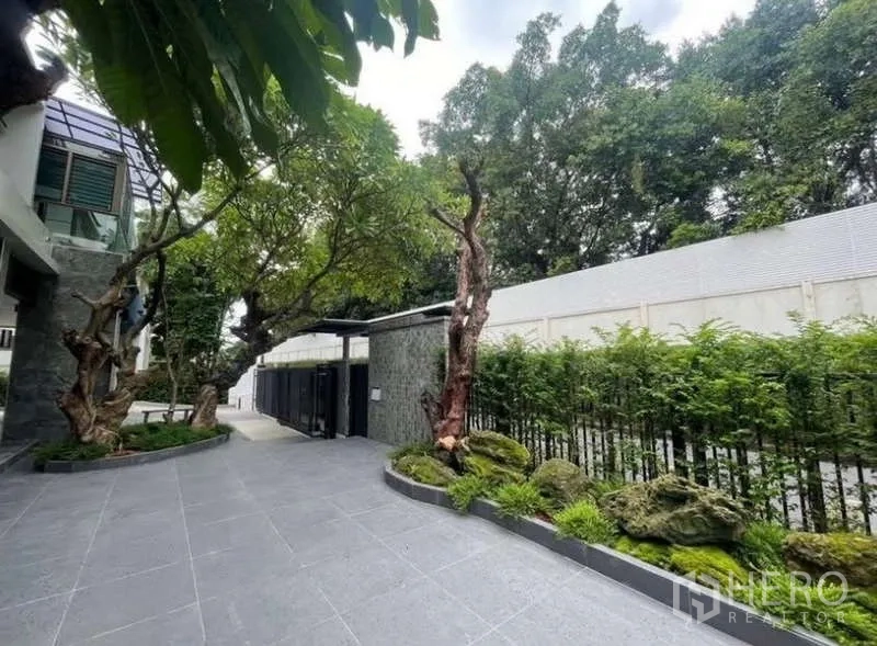 独立式住宅 出售在Khlong Toei, Bangkok - 车道入口，绿篱、石景与金属大门。