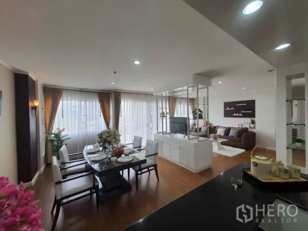 อพาร์ทเมนท์ ให้เช่าในWatthana, Bangkok - มุมมองแบบแปลนเปิด เห็นโต๊ะทานข้าว ชั้นวางทีวี และมุมนั่งเล่นติดกระจกสูง